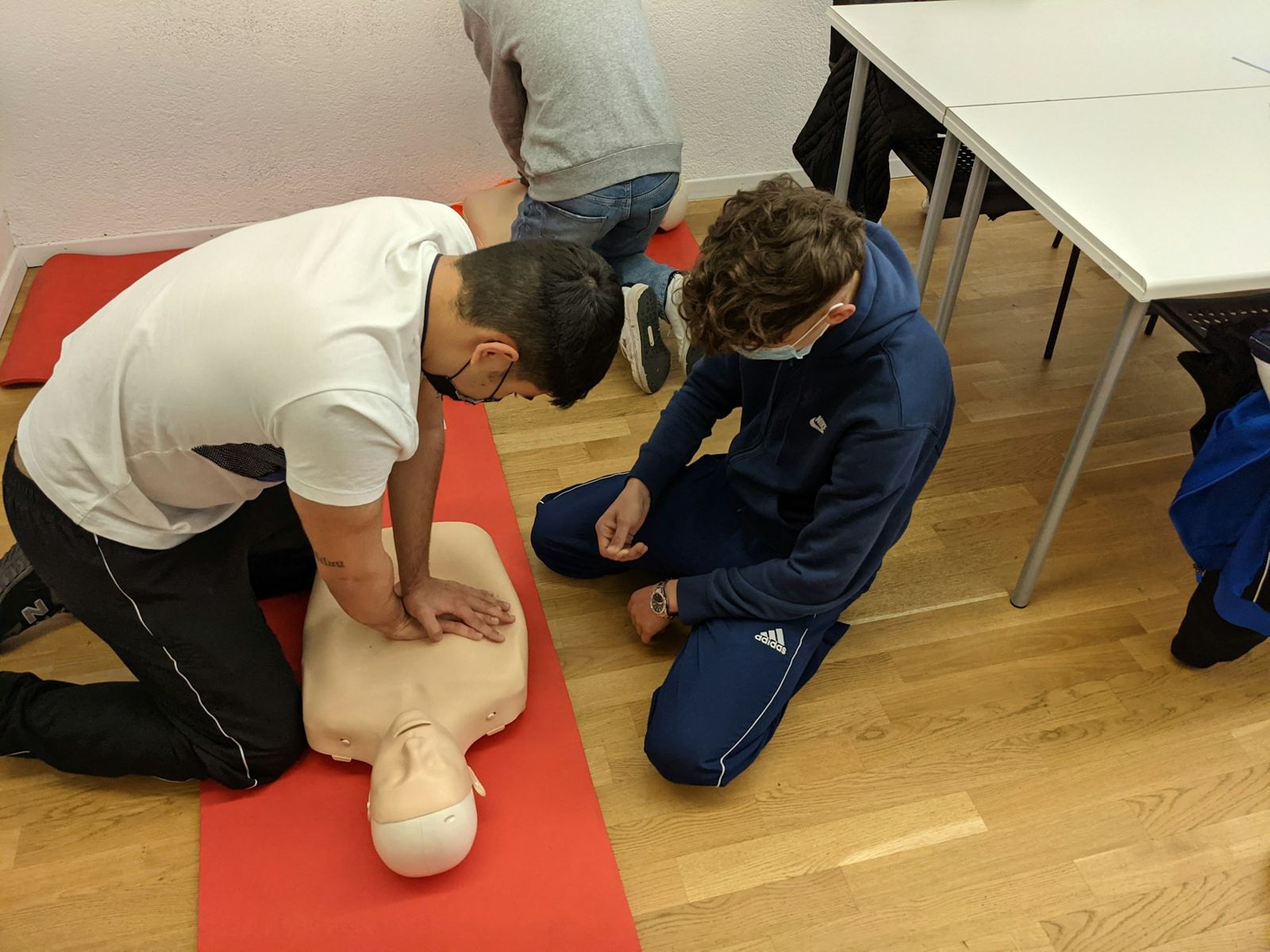 Adults practising CPR in a class